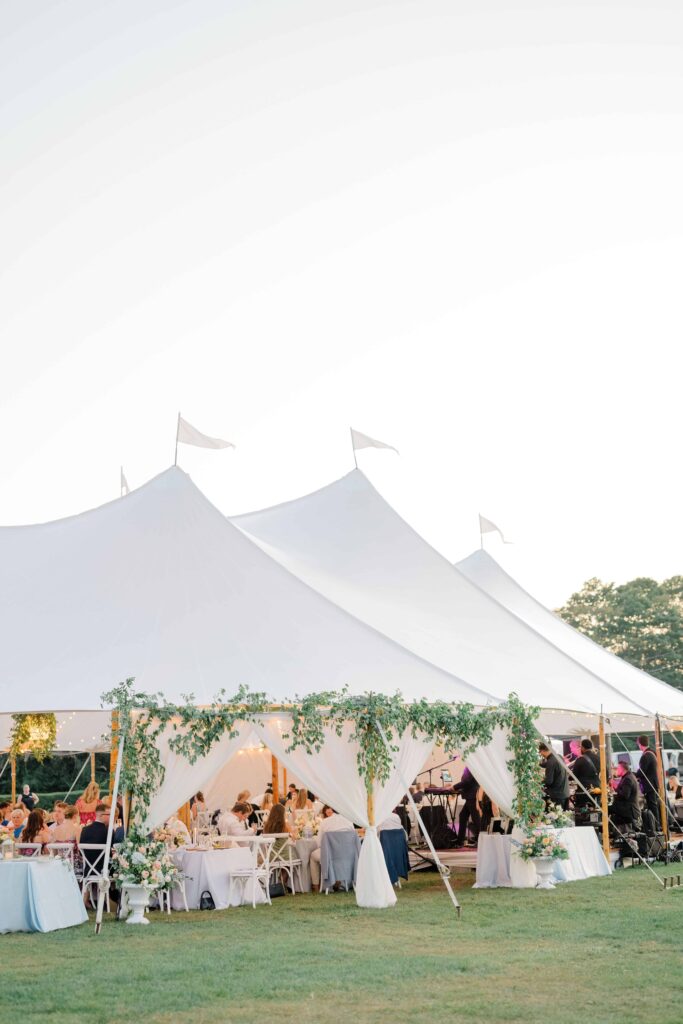 Elegant sailcloth tent glowing at twilight during reception at Eisenhower House Newport Rhode Island.