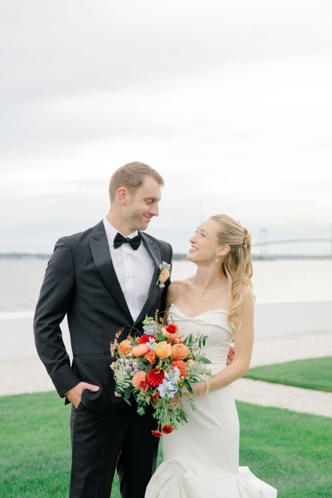 Joyful bride and groom sharing a moment during Belle Mer wedding portraits by the water.