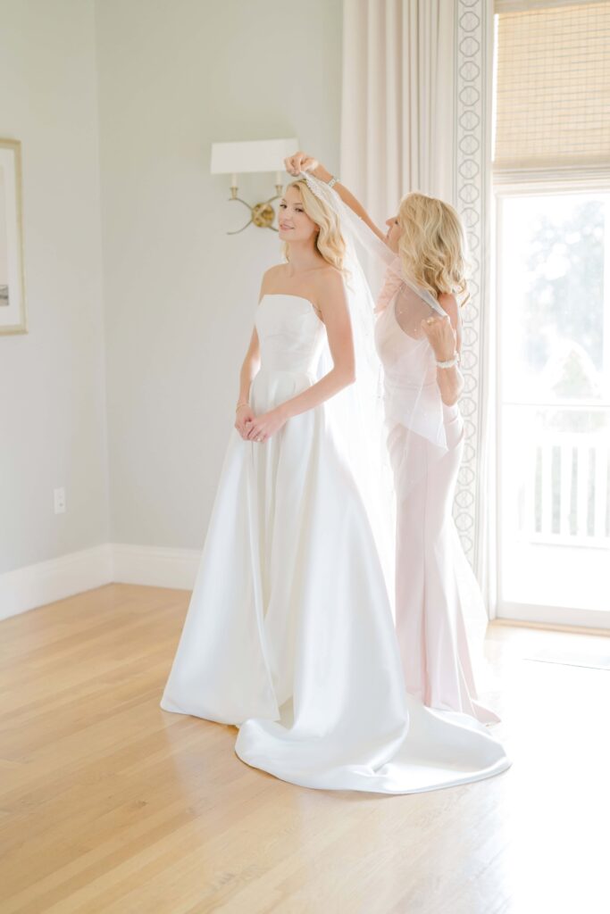 Mother of the bride helping with gown during a coastal wedding morning in Newport, RI.