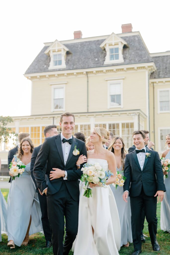 Full wedding party laughing together outside the Eisenhower House in Rhode Island.