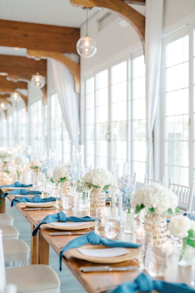 Long reception tables with white florals and blue accents at Wychmere Beach Club