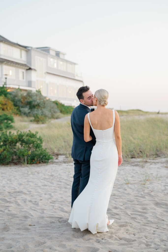 Bride and groom walking along beach at sunset at luxury Wychmere Beach Club wedding