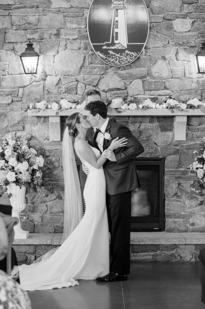 Newlyweds sharing their first kiss surrounded by family and friends at Wentworth by the Sea.