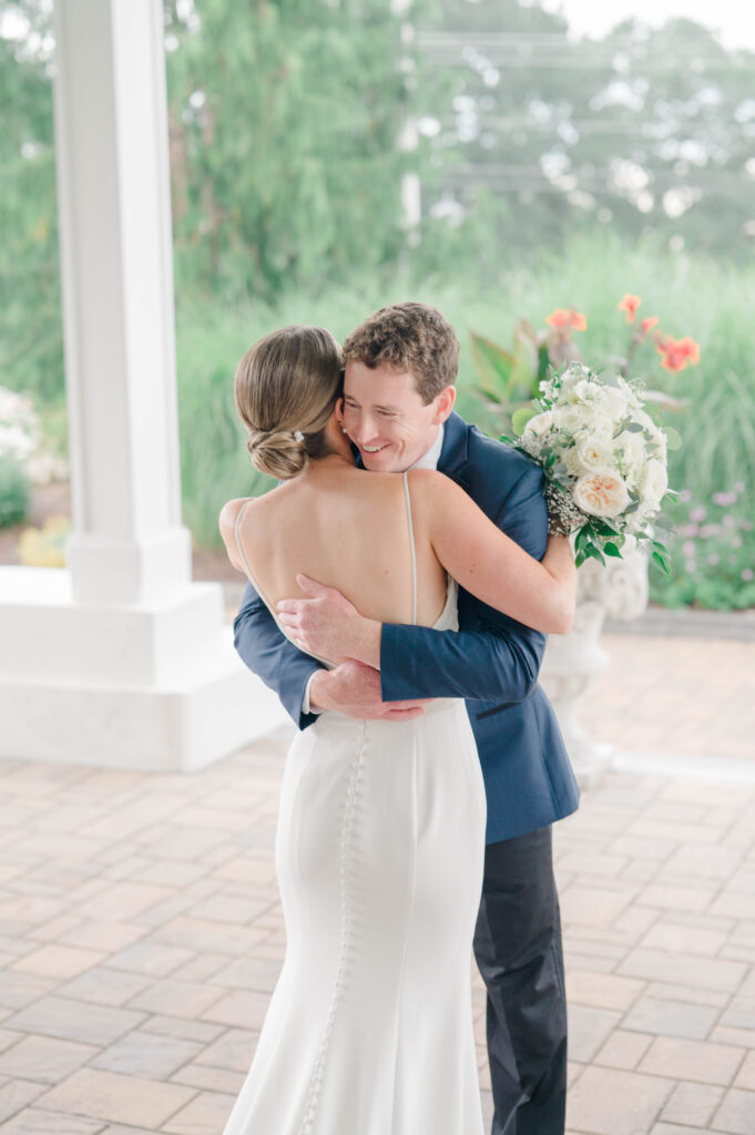 Emotional hug as the bride approaches the groom during their wedding first look.
