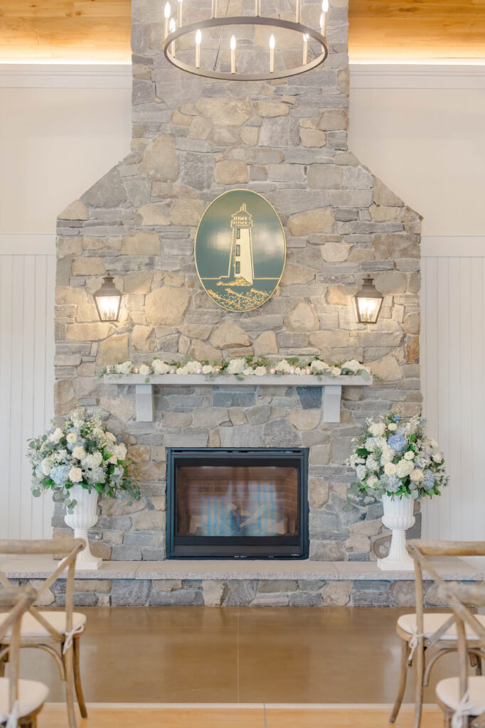 Wedding ceremony setup with elegant floral arrangements at Wentworth by the Sea fireplace.