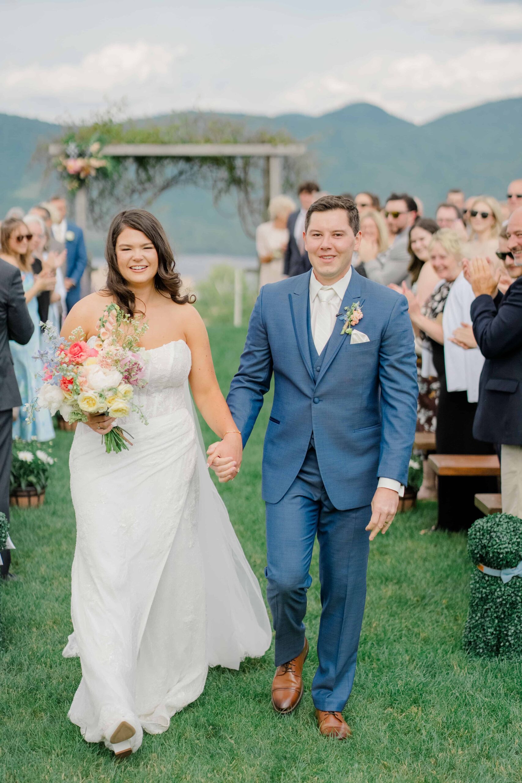 Bride and groom recessional with mountain views at Mountain Top Resort in Chittenden, Vermont.