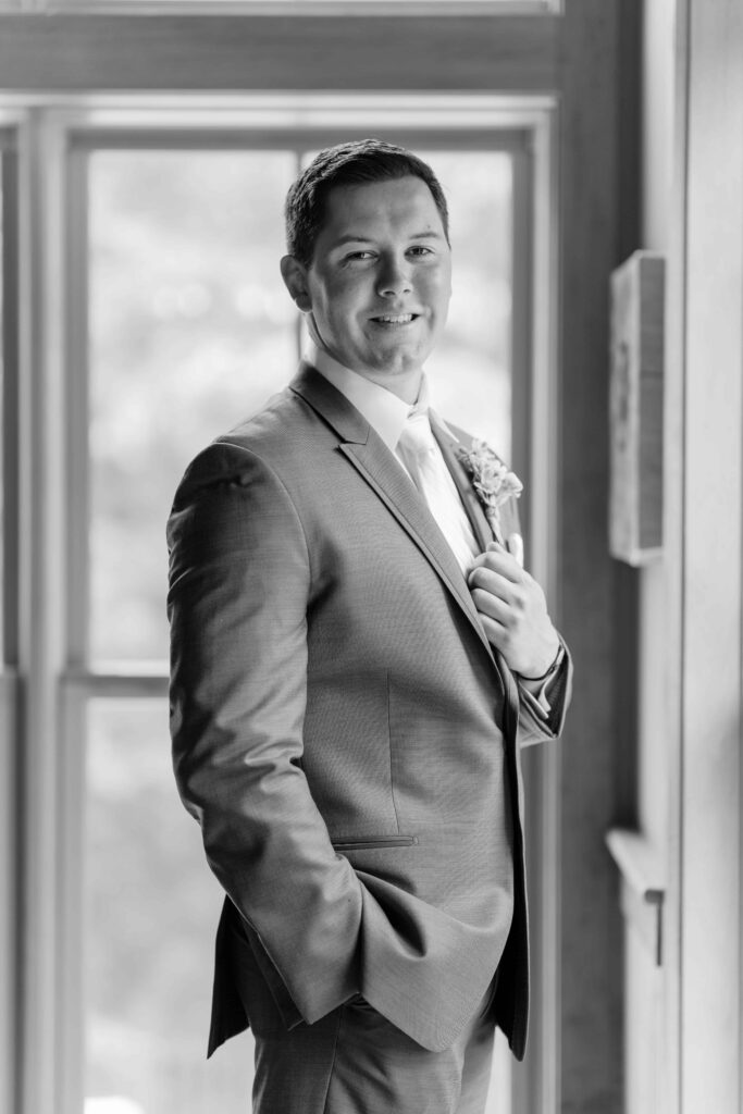 Groom adjusting his tie before the ceremony at Mountain Top Resort Vermont wedding.