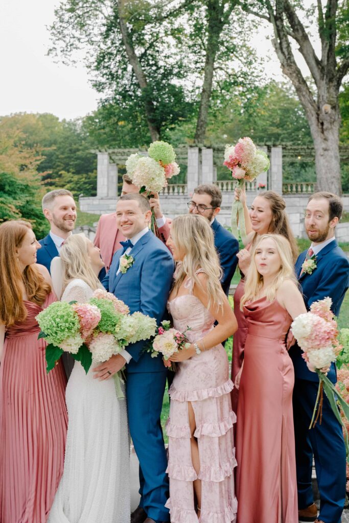 Bridesmaids and groomsmen photographed together during a Vermont wedding, sharing laughter and joy.