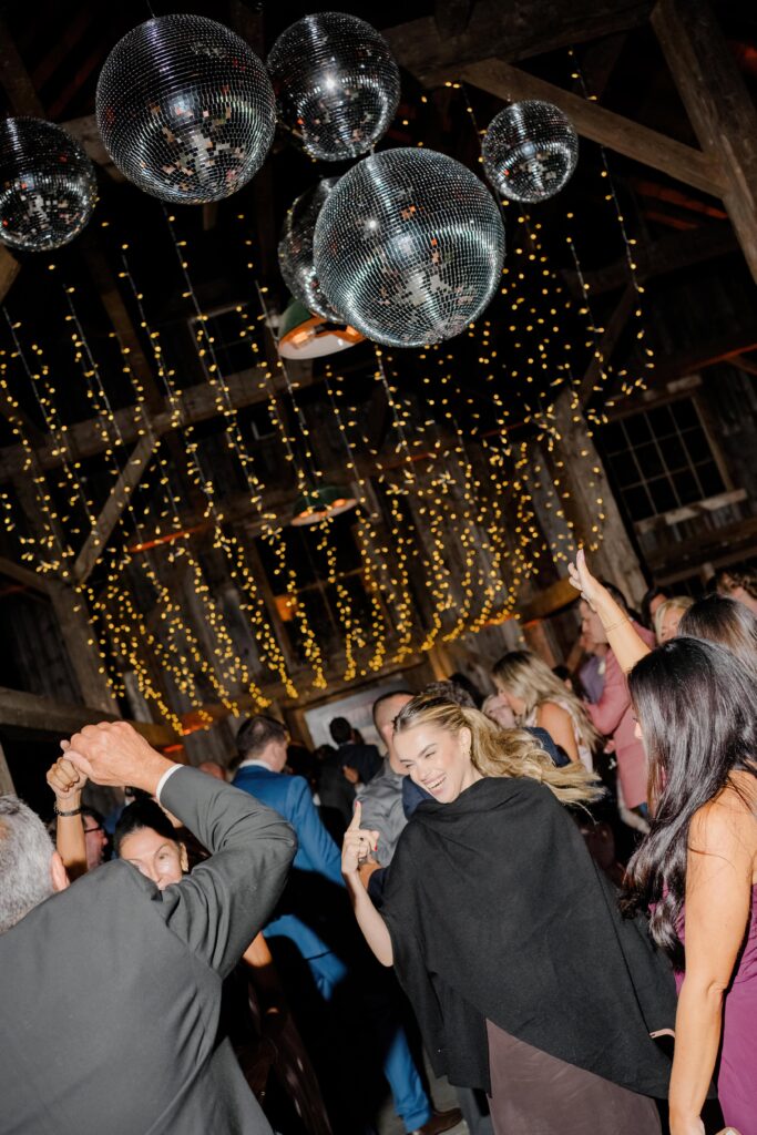 Guests filling the dance floor during a Vermont wedding reception, celebrating with energy and joy.