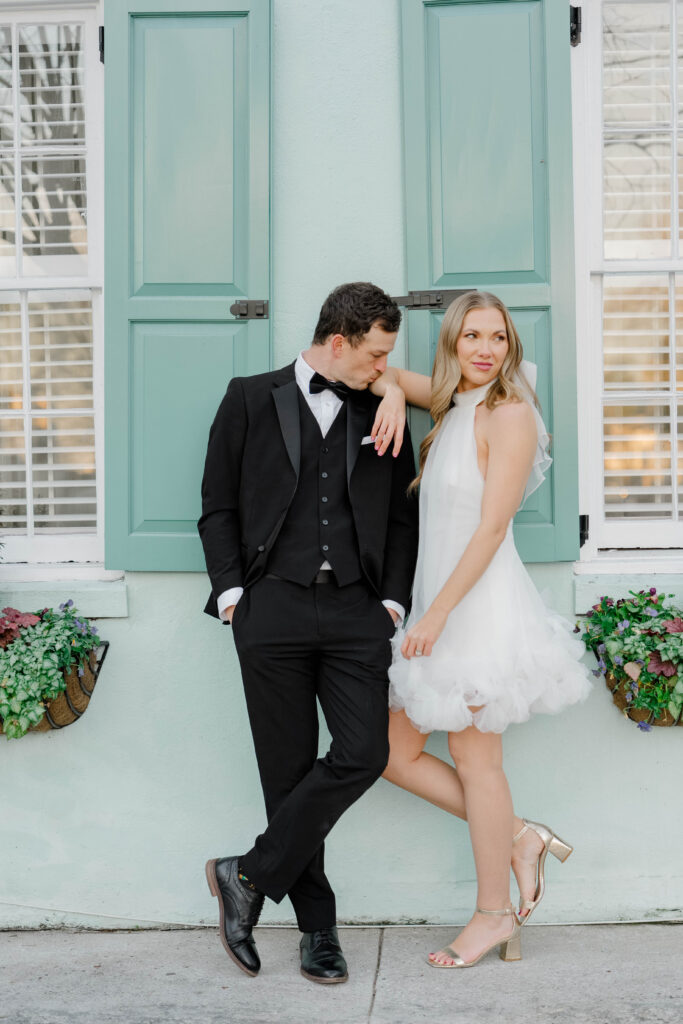 Bride laughing in front of iconic teal shuttered doors in downtown Charleston SC — couples session photography by Felisha Lees Photography