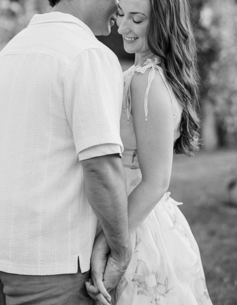 A black-and-white portrait focuses on quiet smiles and hand-holding, emphasizing connection over the setting. Timeless storytelling through Elizabeth Park engagement photos.